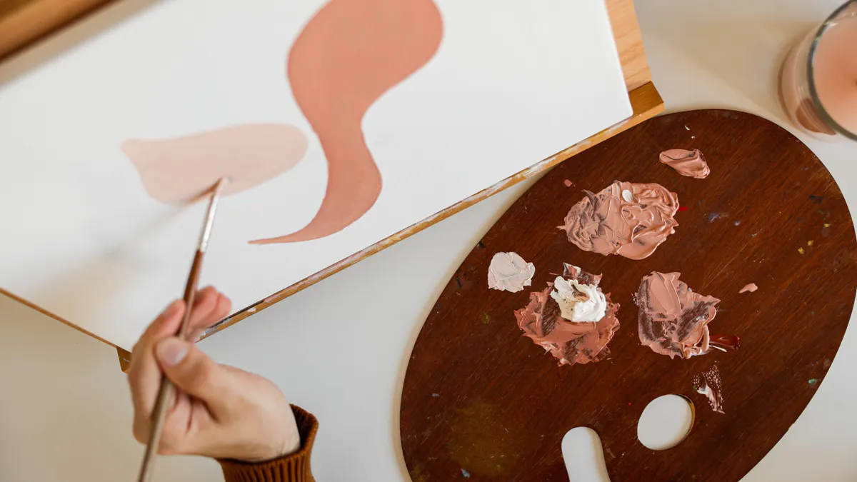 Hand painting abstract shapes on a canvas with a palette