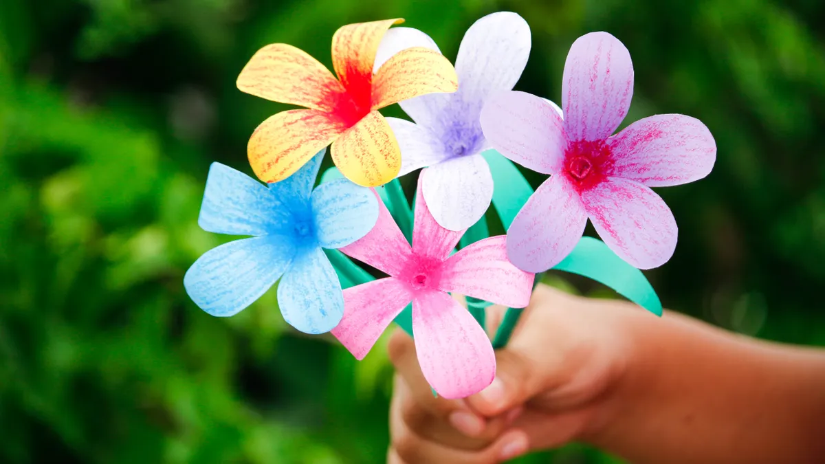 hand holding colorful paper flowers