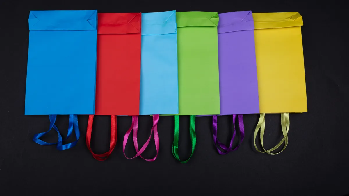 Colorful paper gift bags with ribbon handles